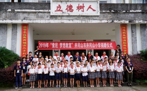 出席嘉宾与井冈山小学师生在校园内合影