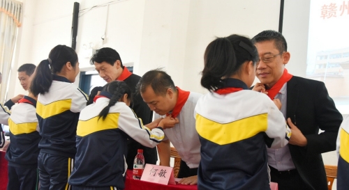 桃江学校学生为参会嘉宾佩戴红领巾