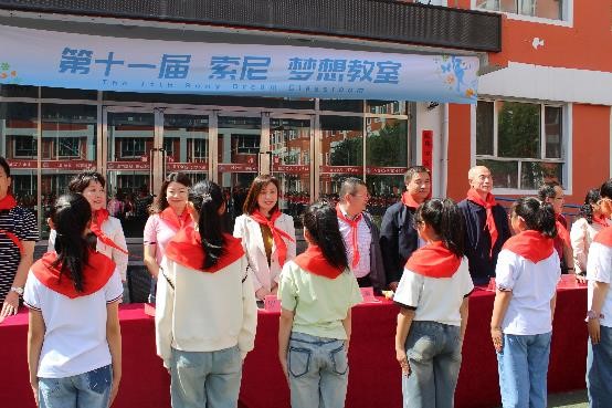 西关小学的孩子们为现场嘉宾佩戴红领巾